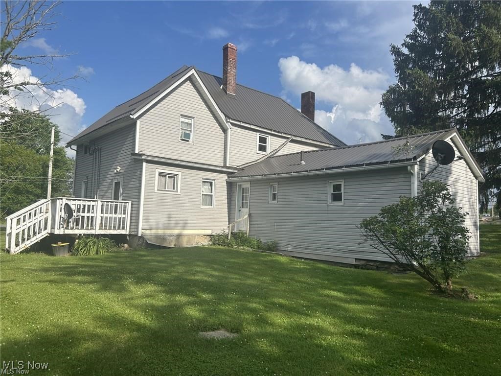 12342 Madison Road Huntsburg, OH 44046 - Photo 14 of 21 Rear view of property featuring a yard, a deck, a metal roof, and a chimney
