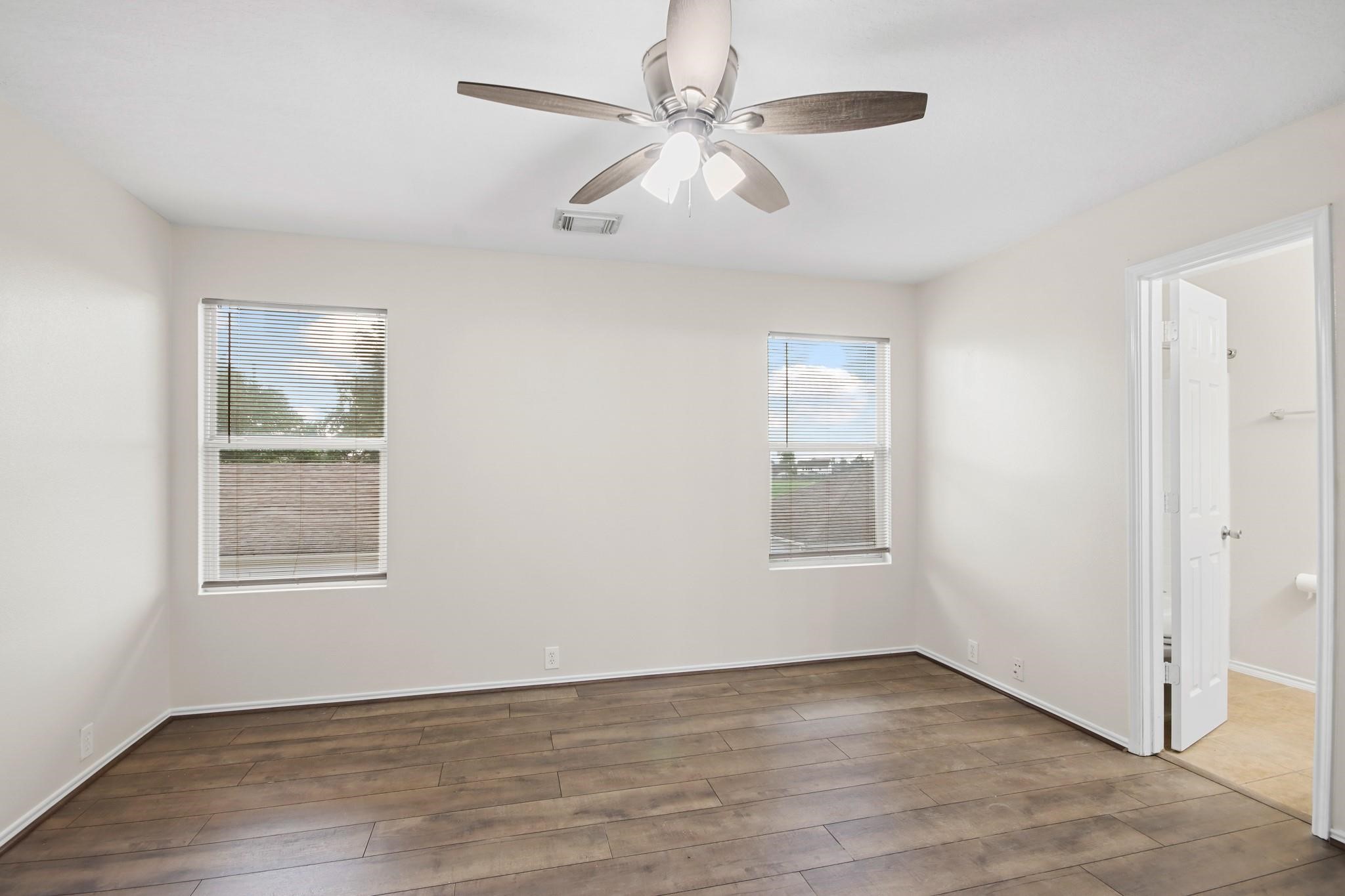 3526 Glenmore Meadow Drive Spring, TX 77386 - Photo 13 of 23 an empty room with wooden floor ceiling fan and windows