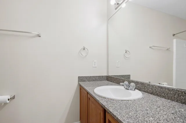 a bathroom with a granite countertop sink and a mirror