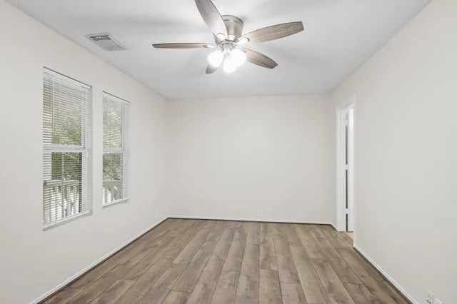 an empty room with a window and a ceiling fan