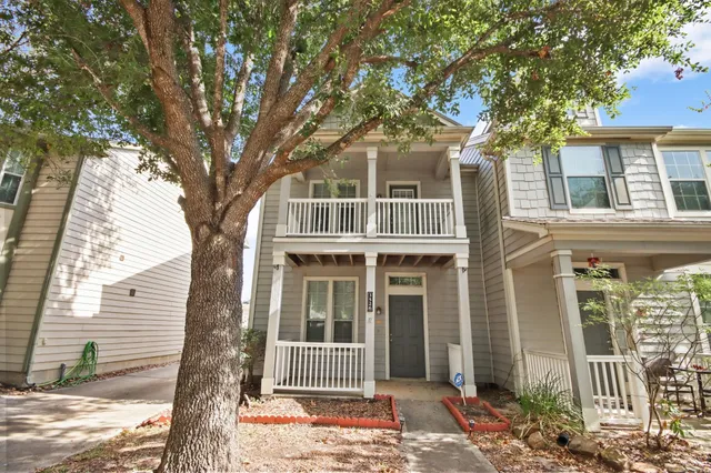 a front view of a house with a tree
