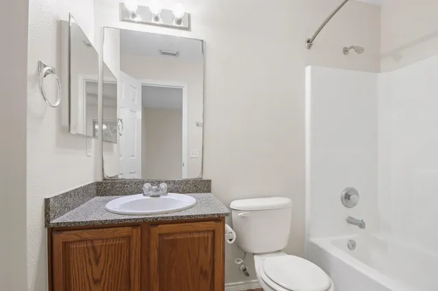 a bathroom with a granite countertop sink toilet and shower
