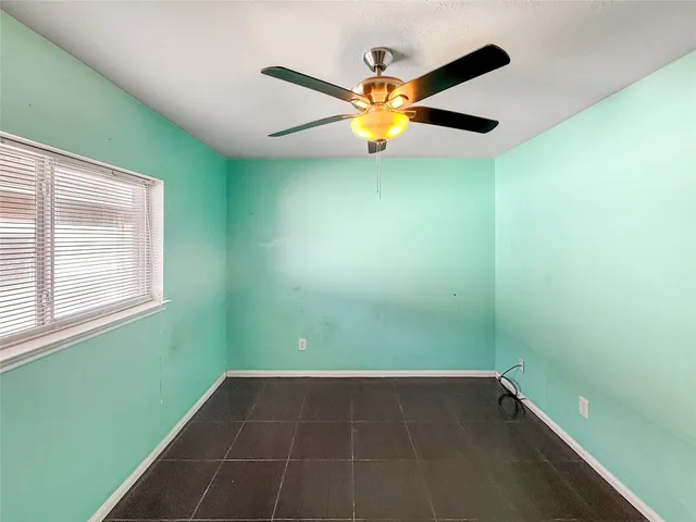 a view of a room that has a window and a ceiling fan