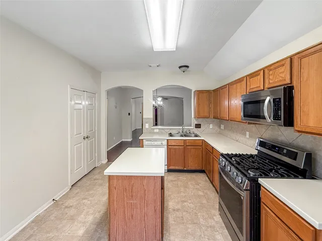 a kitchen with stainless steel appliances a stove a sink and a refrigerator