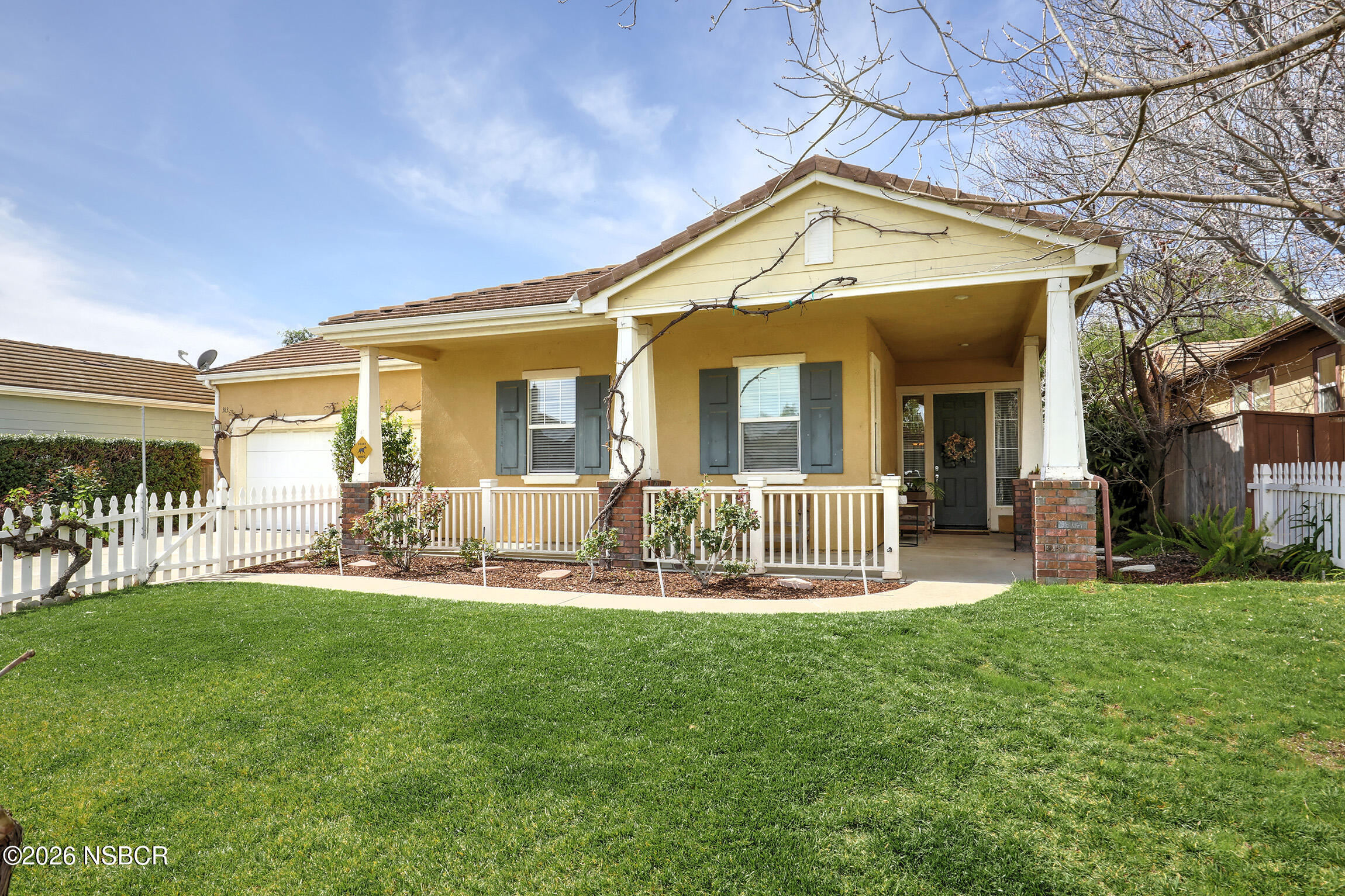 a front view of house with a garden and patio