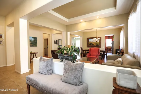 a dining room with wooden floor and large windows