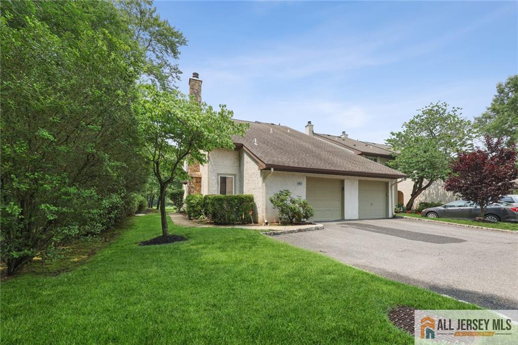 a front view of a house with a yard and trees