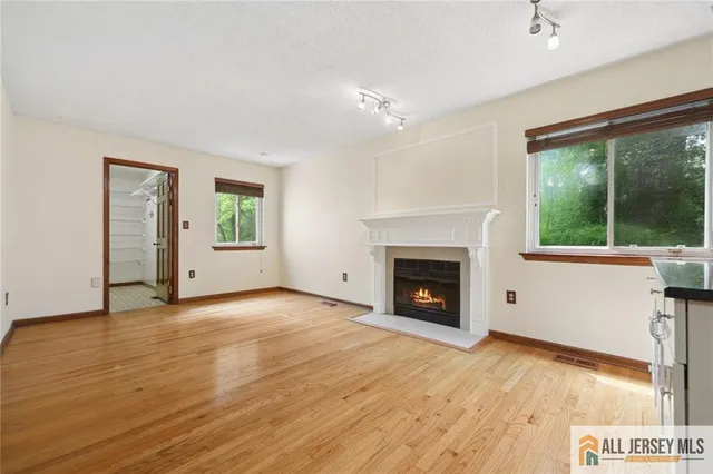 wooden floor fireplace and windows in an empty room