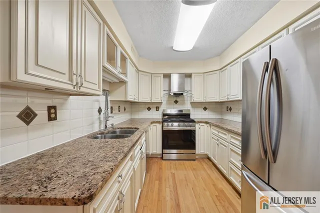 a kitchen with stainless steel appliances granite countertop a refrigerator and a sink