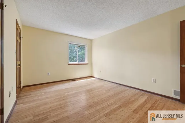 an empty room with a wooden floor and a window