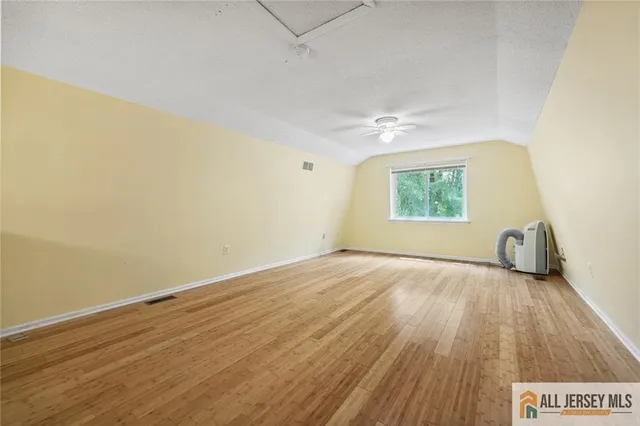 an empty room with a window and wooden floor