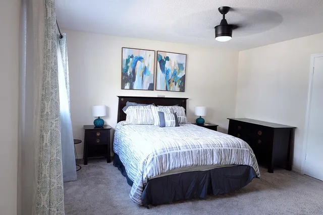 a bedroom with a bed and a painting on the wall