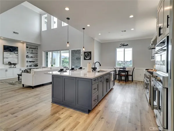 a kitchen with counter top space a sink stainless steel appliances and windows