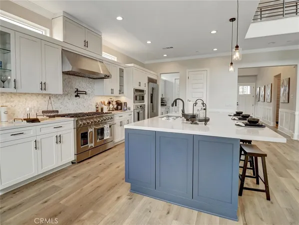 a kitchen with stainless steel appliances granite countertop a sink a stove and cabinets