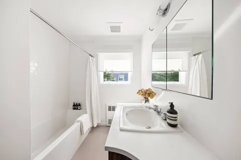 a bathroom with a sink a tub and a window