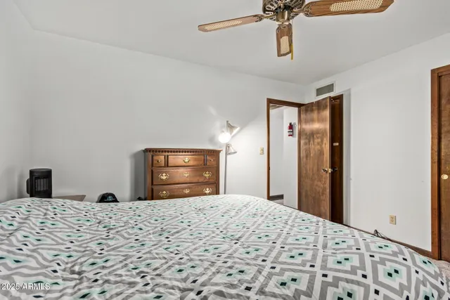 a bedroom with a bed and a flat tv screen on dresser