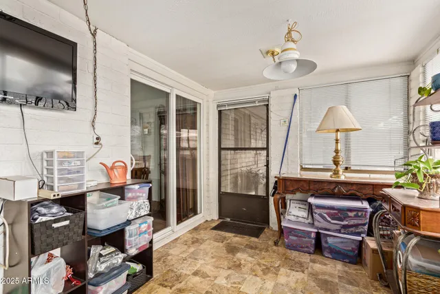 a view of a workspace with furniture and a window