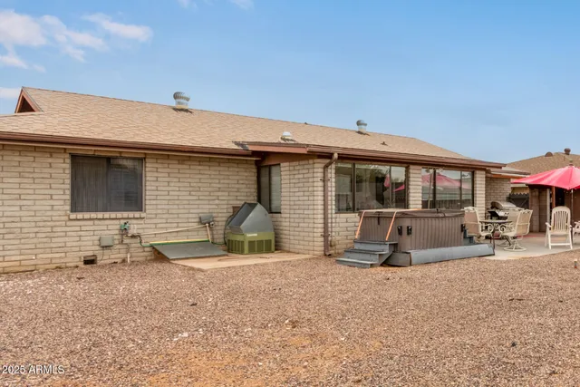 a view of a house with backyard and sitting area