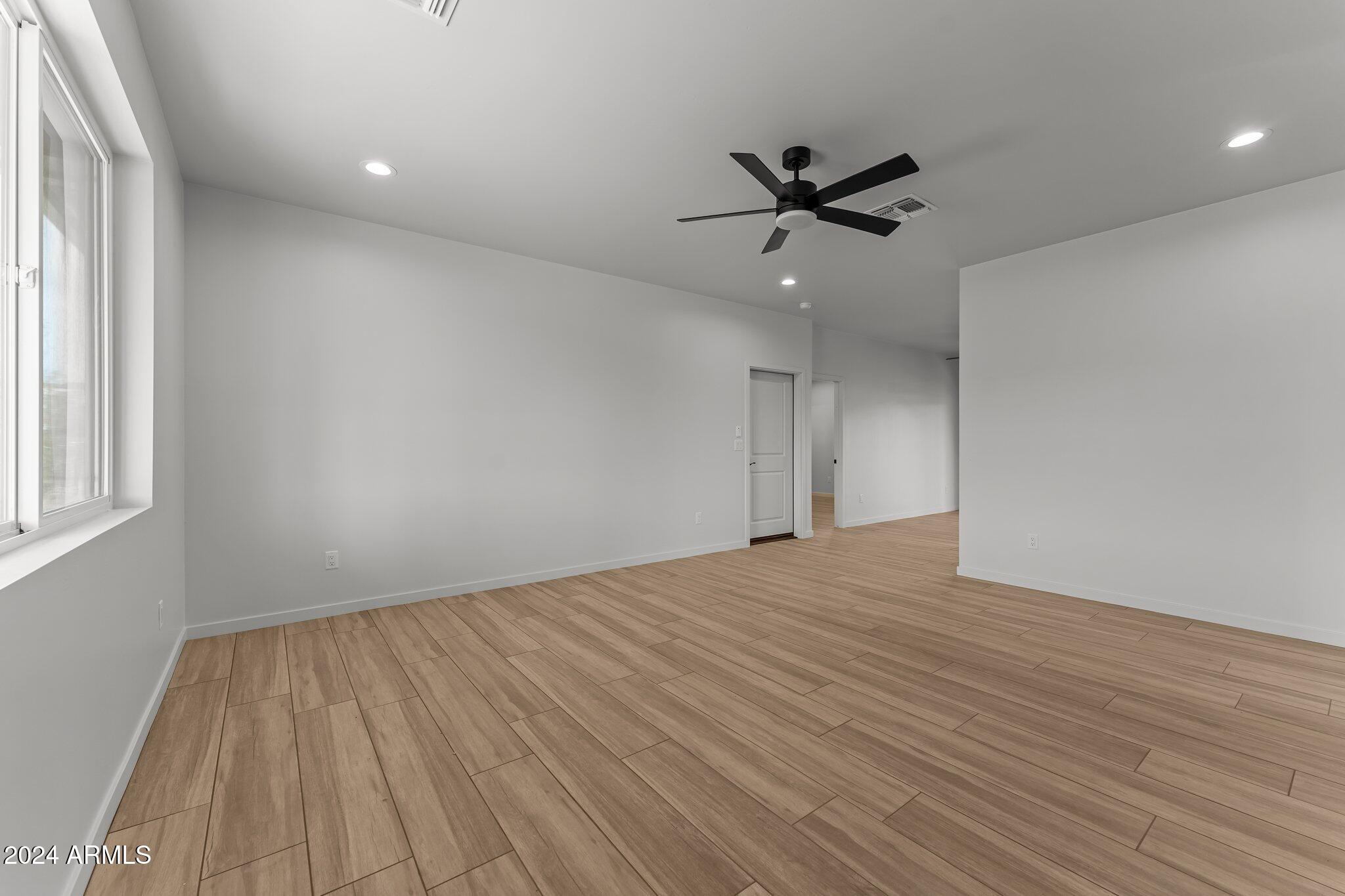 18473 Henry Coe Road Peeples Valley, AZ 86332 - Photo 12 of 31 wooden floor in an empty room with a window