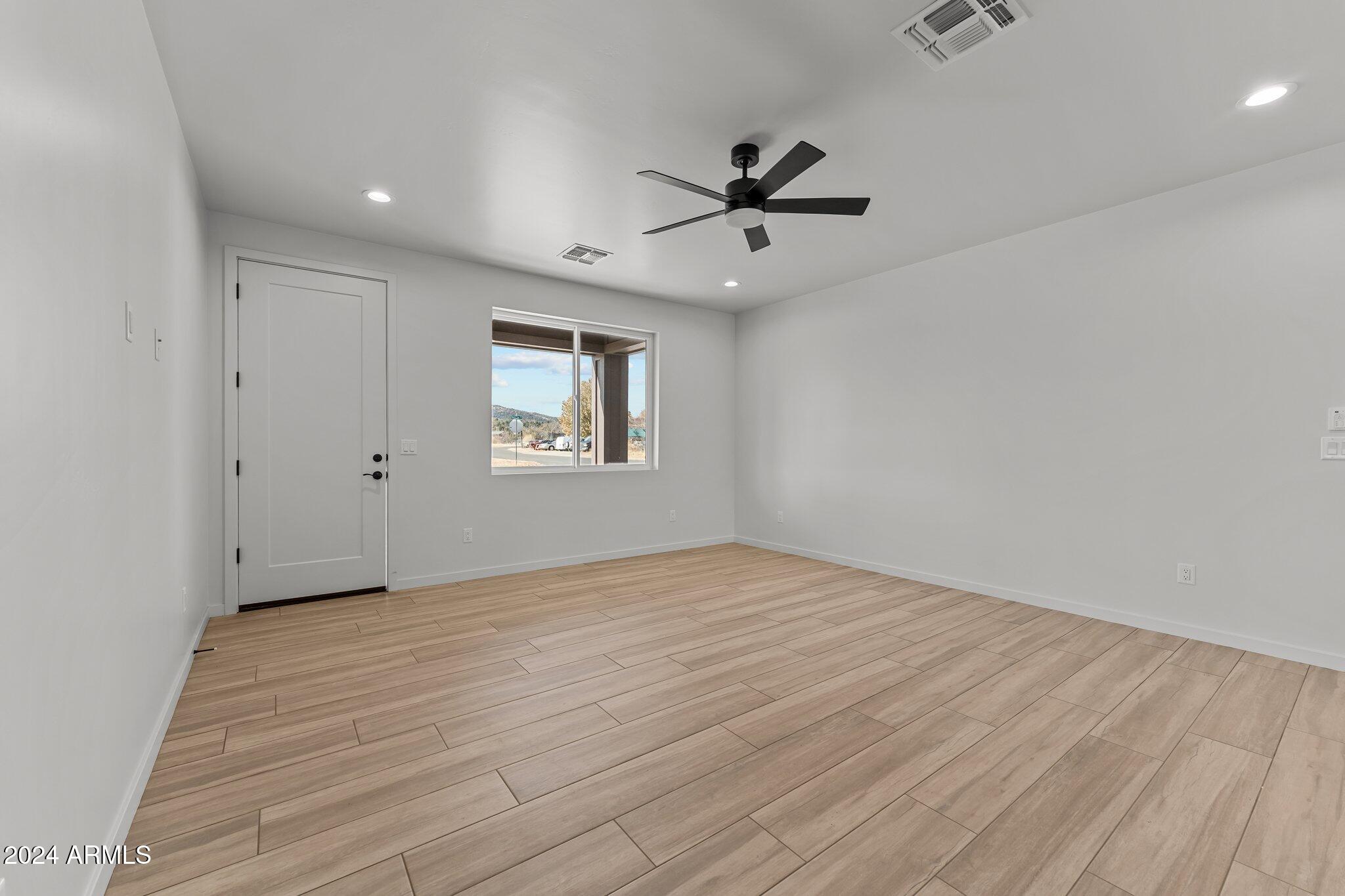 18473 Henry Coe Road Peeples Valley, AZ 86332 - Photo 15 of 31 a view of empty room with wooden floor and fan