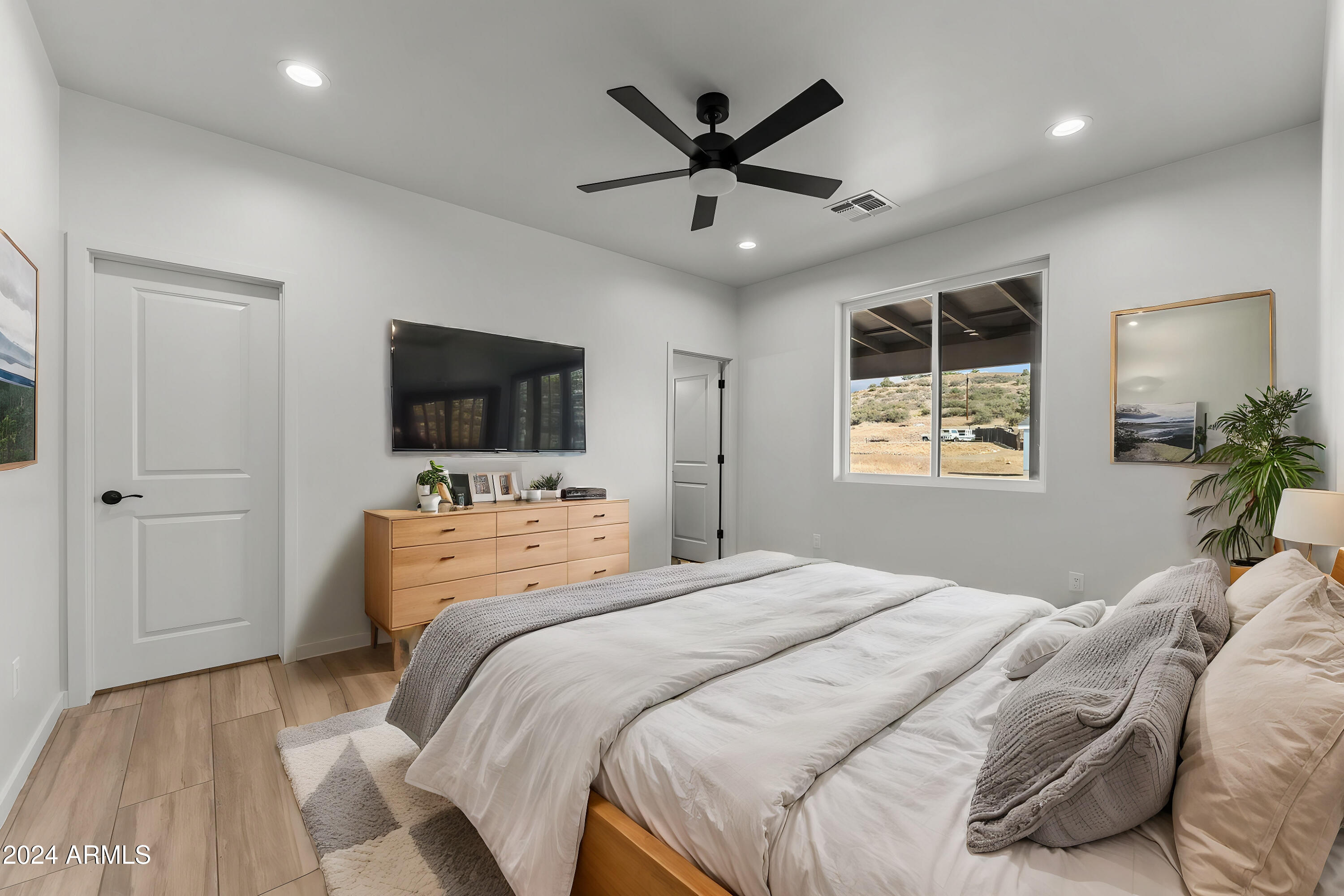 18473 Henry Coe Road Peeples Valley, AZ 86332 - Photo 16 of 31 a bedroom with a large bed and a flat screen tv