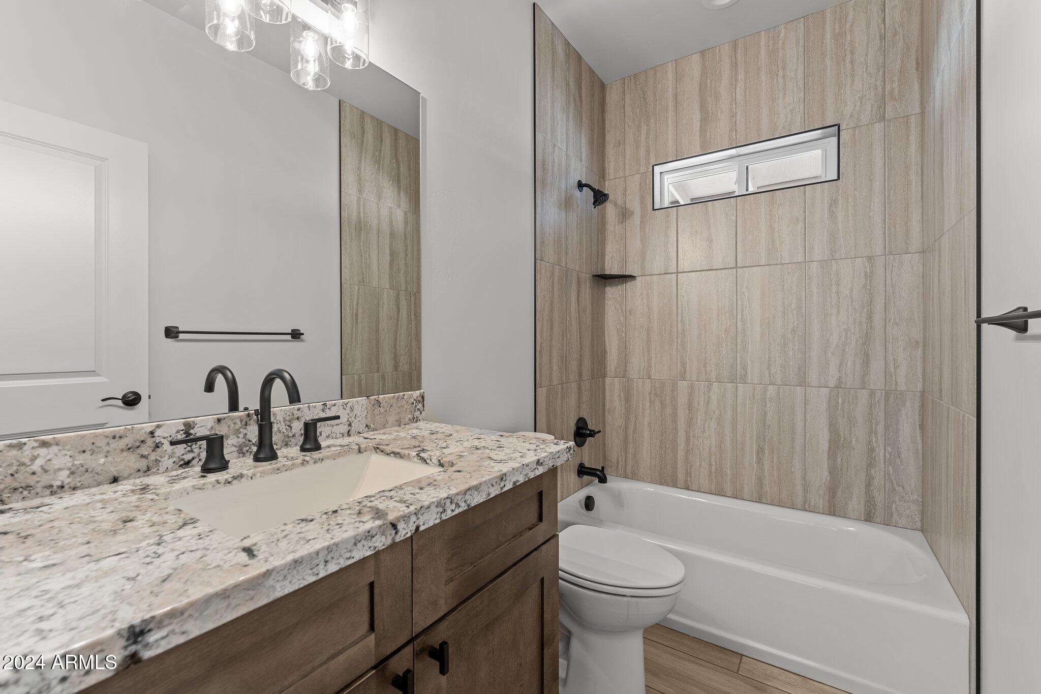 18473 Henry Coe Road Peeples Valley, AZ 86332 - Photo 25 of 31 a bathroom with a granite countertop sink toilet and shower