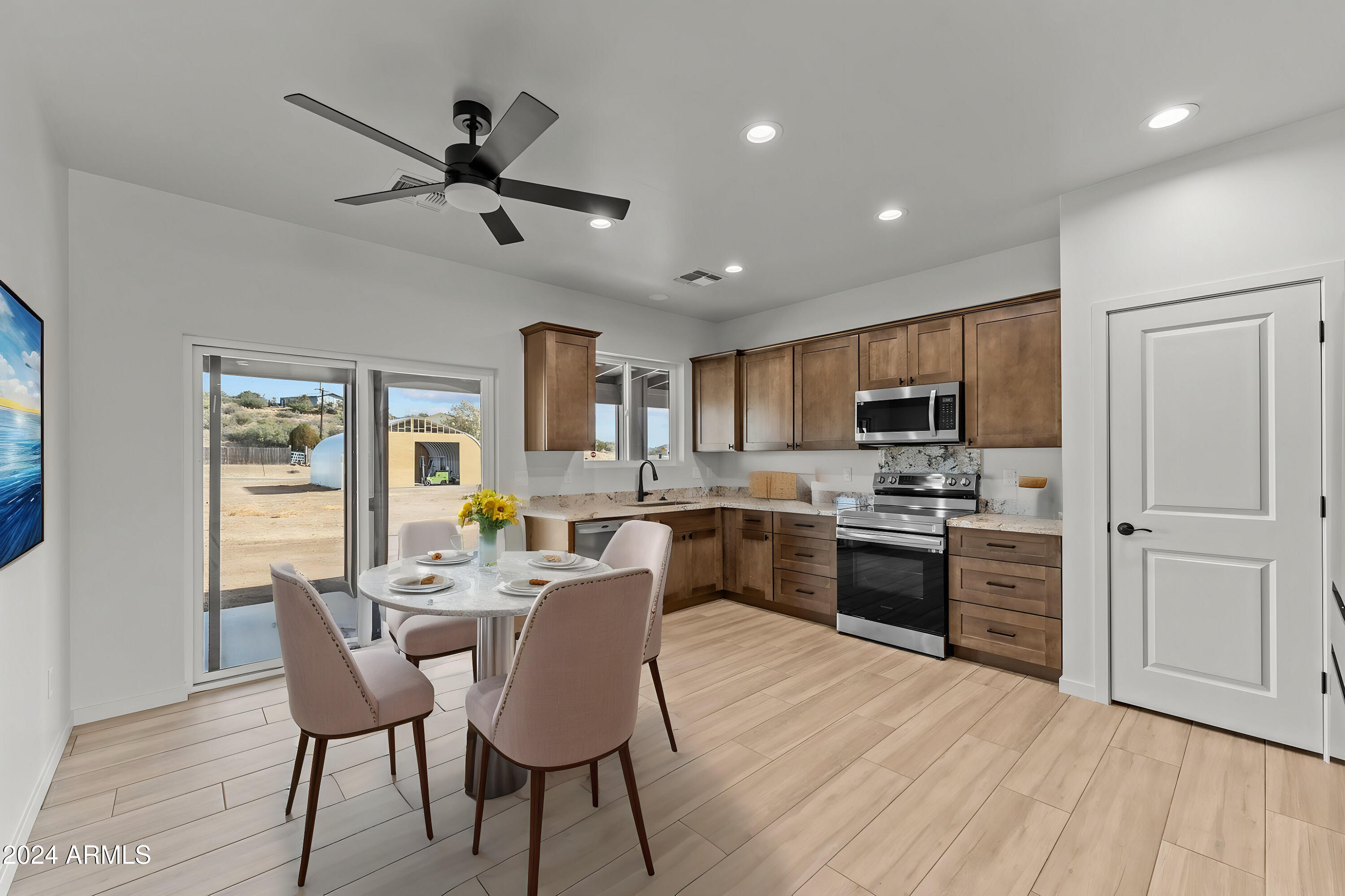 18473 Henry Coe Road Peeples Valley, AZ 86332 - Photo 5 of 31 a kitchen with a table chairs refrigerator and cabinets