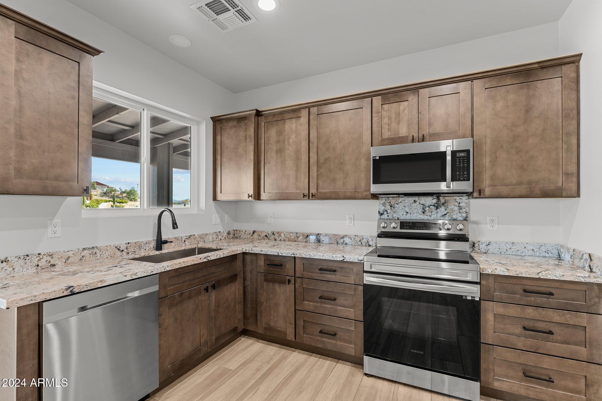 18473 Henry Coe Road Peeples Valley, AZ 86332 - Photo 6 of 31 a kitchen with a sink stove and microwave