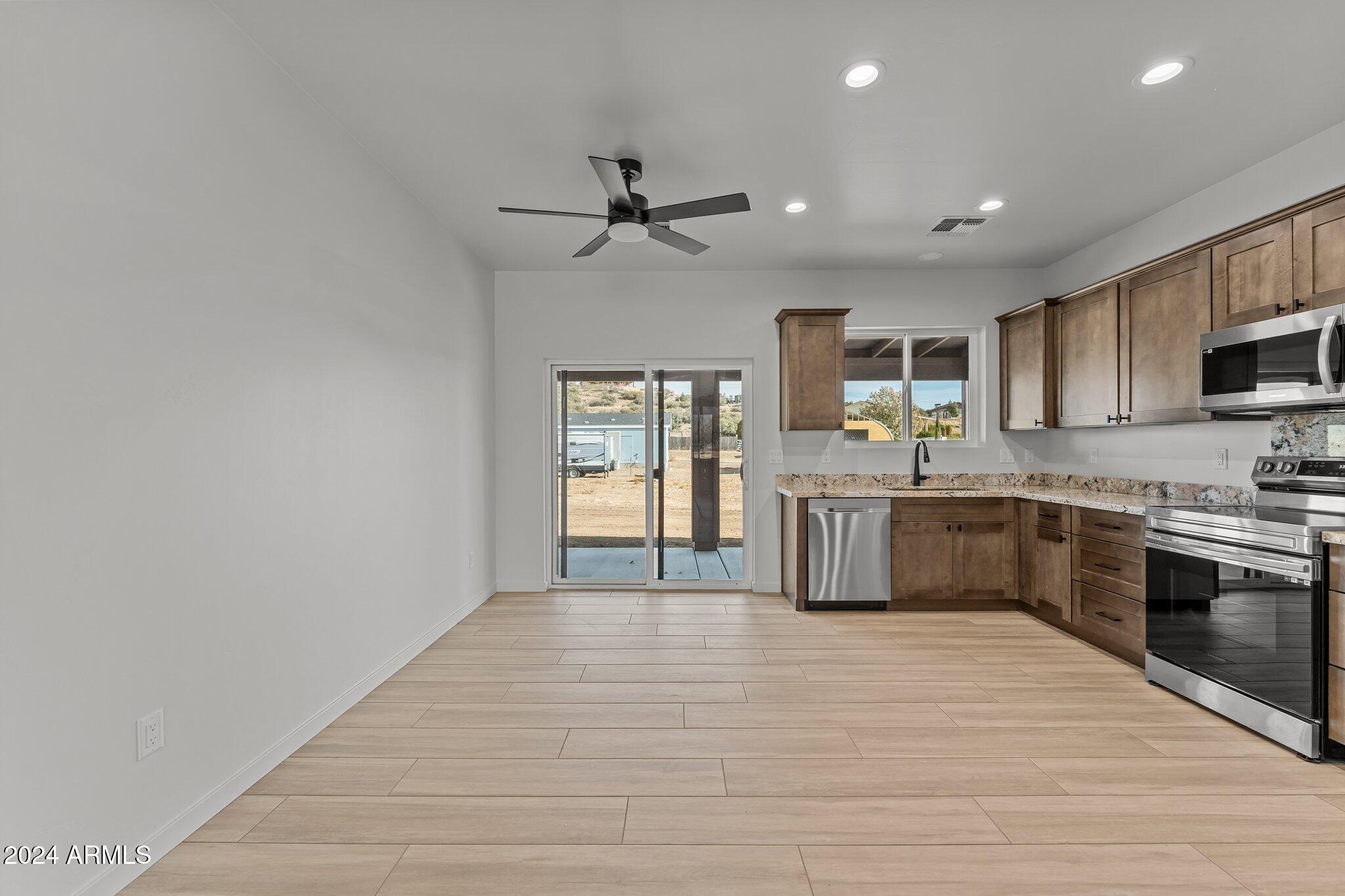 18473 Henry Coe Road Peeples Valley, AZ 86332 - Photo 8 of 31 a large kitchen with stainless steel appliances granite countertop a sink a stove and a refrigerator