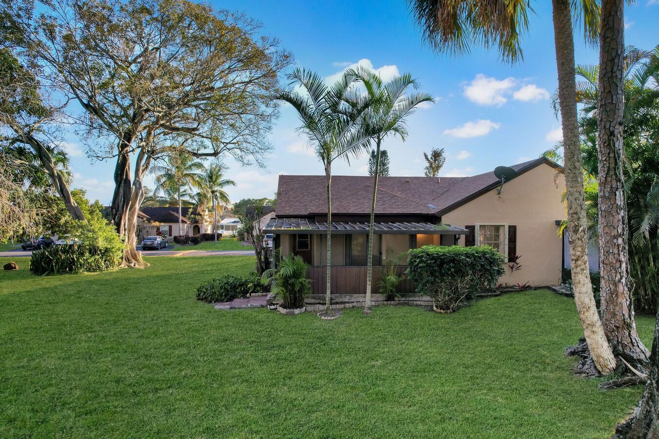 22355 Southwest 57th Circle Boca Raton, FL 33428 - Photo 15 of 25 a front view of house with yard and outdoor seating
