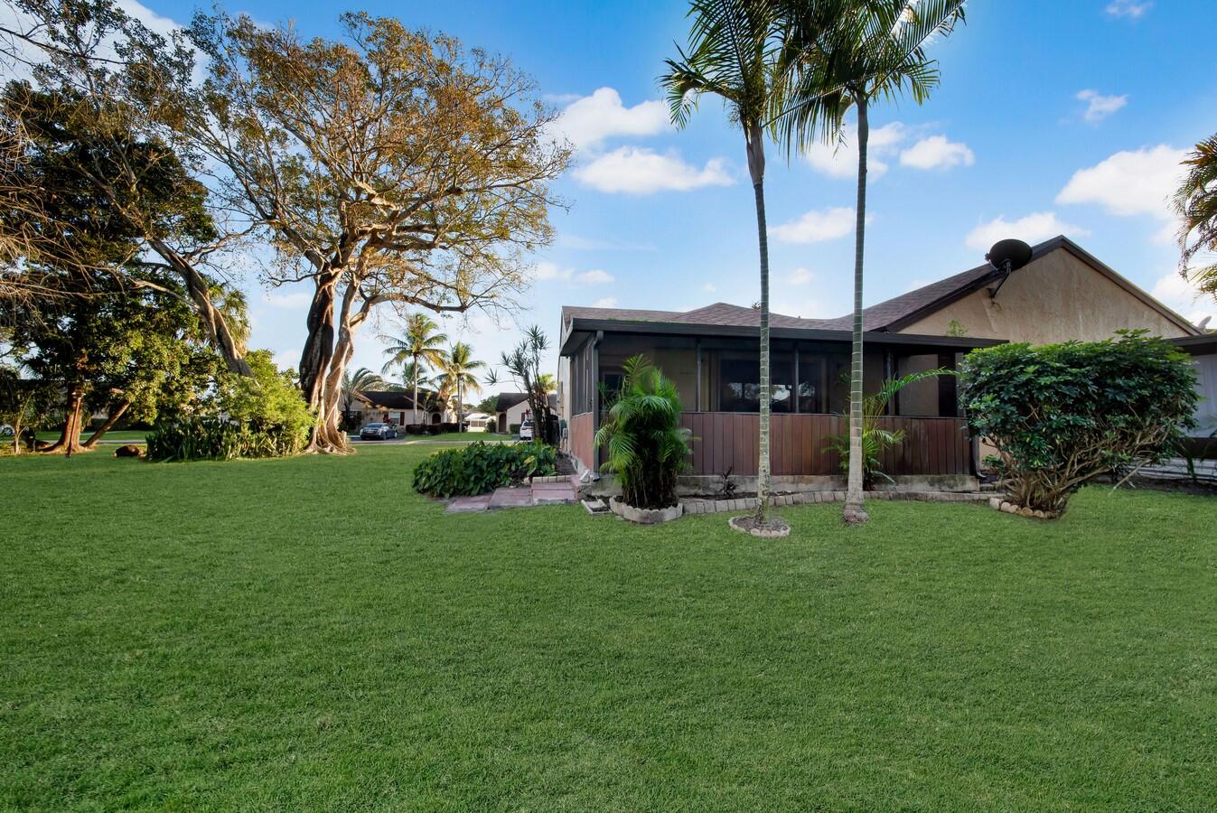 22355 Southwest 57th Circle Boca Raton, FL 33428 - Photo 17 of 25 a view of a house with a yard and potted plants