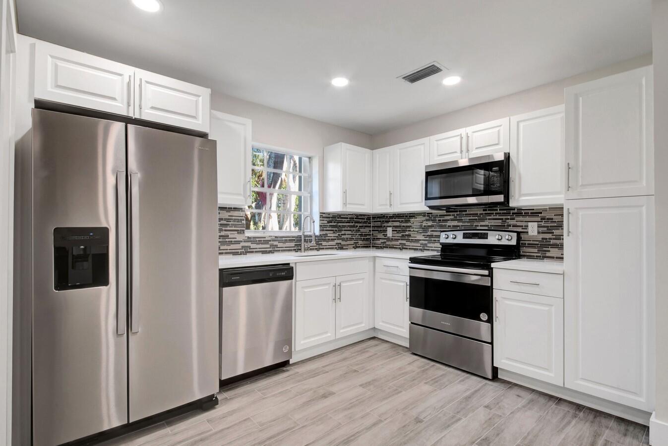 22355 Southwest 57th Circle Boca Raton, FL 33428 - Photo 4 of 25 a kitchen with stainless steel appliances a refrigerator stove and microwave