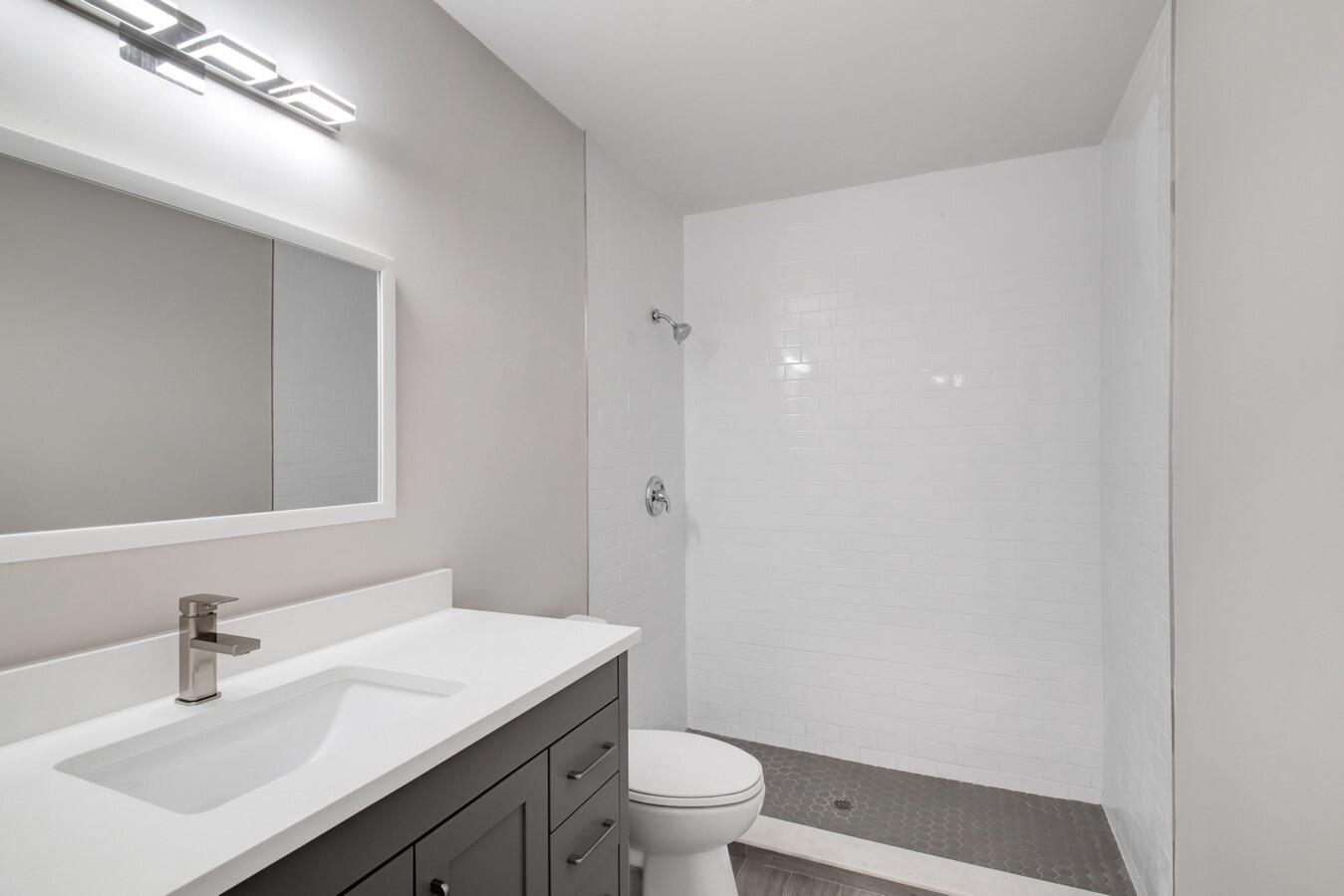 22355 Southwest 57th Circle Boca Raton, FL 33428 - Photo 7 of 25 a bathroom with a sink a toilet a light fixture and a mirror