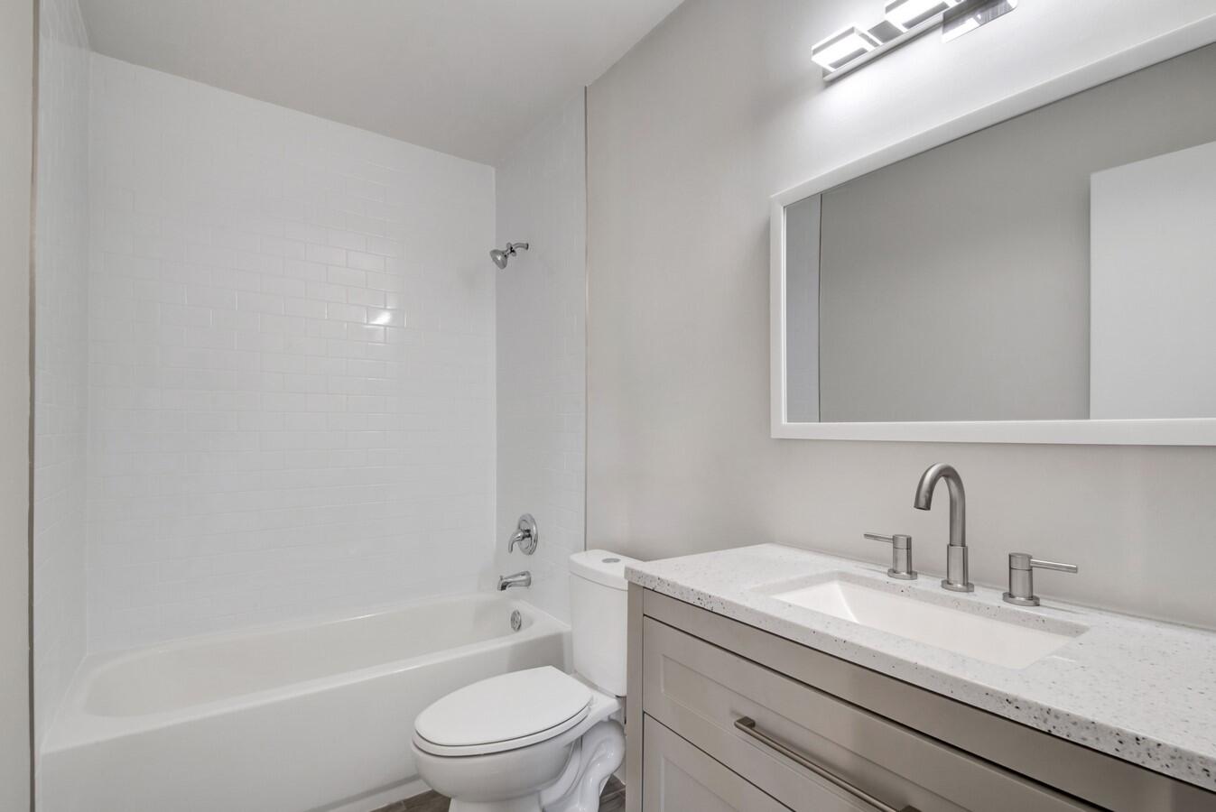 22355 Southwest 57th Circle Boca Raton, FL 33428 - Photo 9 of 25 a bathroom with a granite countertop toilet a sink and a bathtub