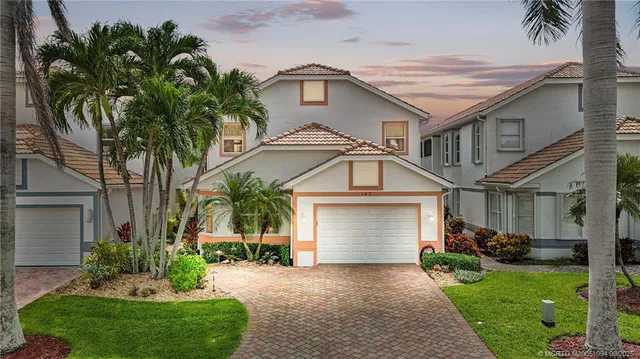 a front view of a house with a garden and plants