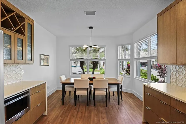 a dining room with furniture a chandelier and wooden floor