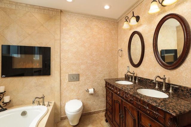 a bathroom with a granite countertop sink a mirror and a toilet