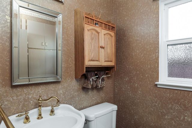 a bathroom with a sink a toilet and mirror