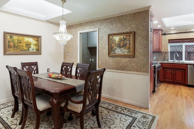 a view of a dining room with furniture wooden floor and a chandelier