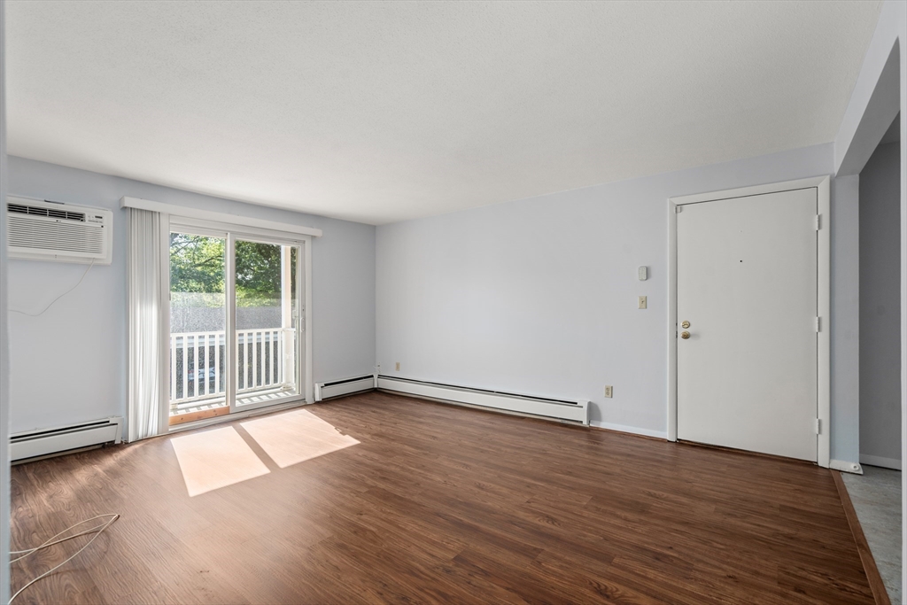 88 Beacon Street, Unit 7 Lawrence, MA 01843 - Photo 11 of 34 an empty room with wooden floor and windows