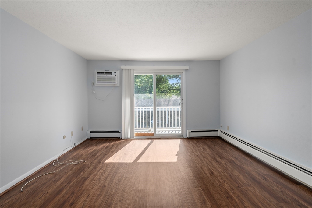 88 Beacon Street, Unit 7 Lawrence, MA 01843 - Photo 12 of 34 a view of an empty room with wooden floor and a window