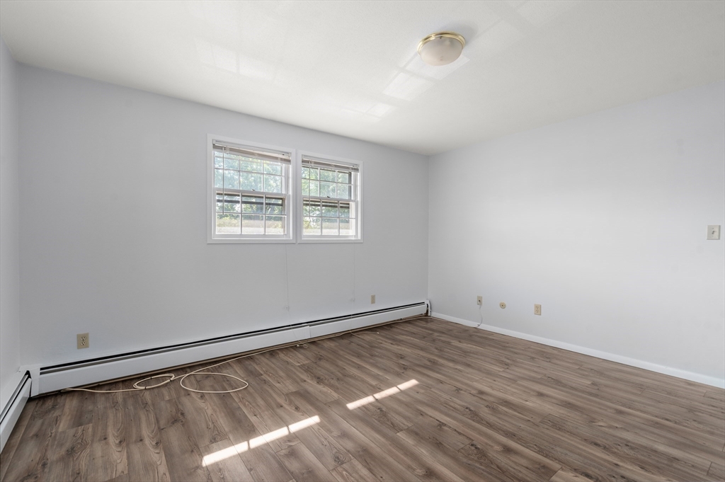 88 Beacon Street, Unit 7 Lawrence, MA 01843 - Photo 15 of 34 a view of an empty room with wooden floor and a window