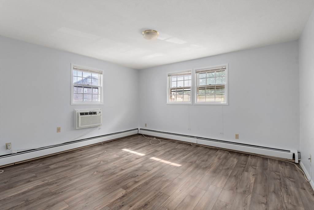 88 Beacon Street, Unit 7 Lawrence, MA 01843 - Photo 16 of 34 an empty room with wooden floor and windows