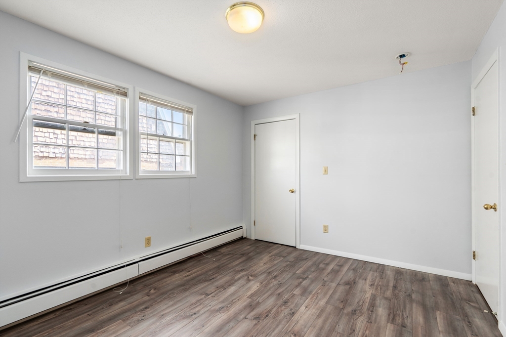 88 Beacon Street, Unit 7 Lawrence, MA 01843 - Photo 21 of 34 an empty room with wooden floor and windows