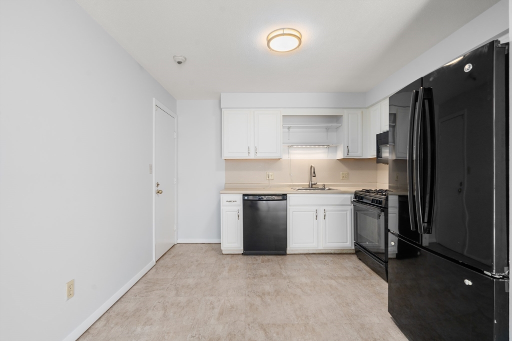 88 Beacon Street, Unit 7 Lawrence, MA 01843 - Photo 4 of 34 a kitchen with a refrigerator stove and sink