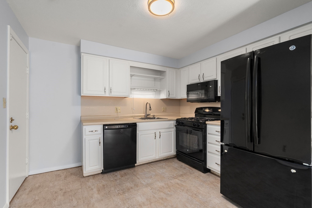 88 Beacon Street, Unit 7 Lawrence, MA 01843 - Photo 5 of 34 a kitchen with a refrigerator stove and microwave