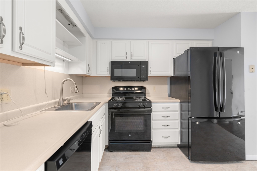 88 Beacon Street, Unit 7 Lawrence, MA 01843 - Photo 6 of 34 a kitchen with a sink and a refrigerator