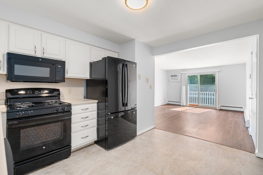 88 Beacon Street, Unit 7 Lawrence, MA 01843 - Photo 7 of 34 a kitchen with granite countertop a refrigerator and a stove top oven