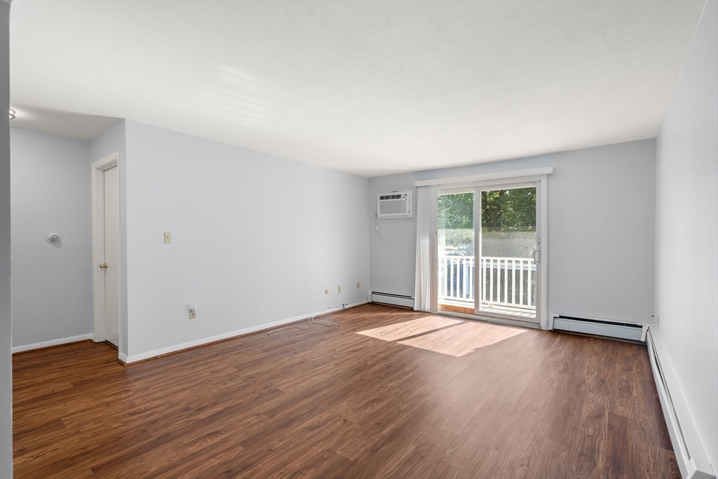 88 Beacon Street, Unit 7 Lawrence, MA 01843 - Photo 10 of 34 a view of an empty room with wooden floor and a window