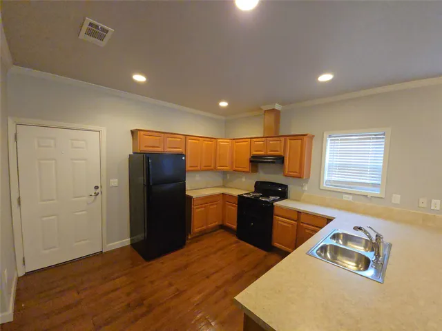 a kitchen with a refrigerator and a stove top oven